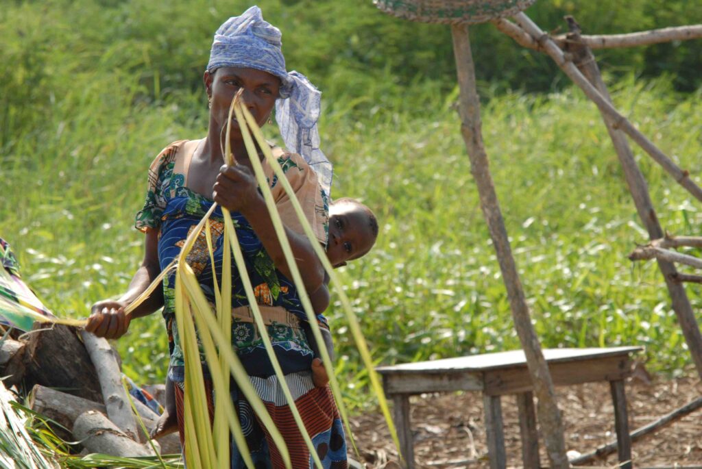 Lady working during the day with her child on her back near lokpo